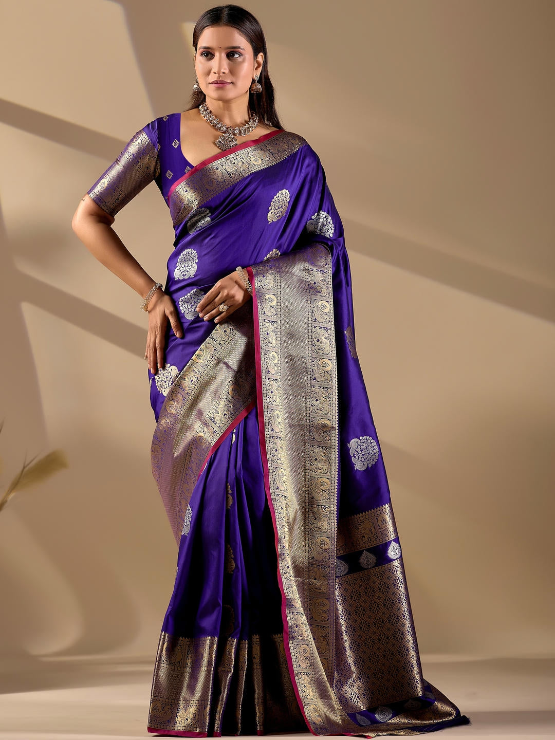 Beautiful woman styled in a blue woven design silk saree featuring a heavy zari border and solid blouse by Samantha.