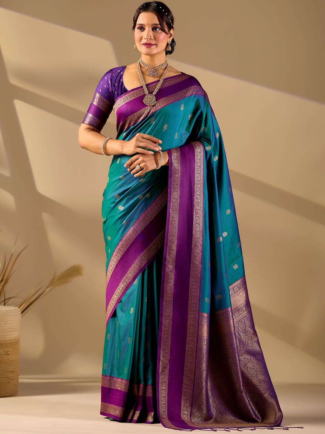 Beautiful woman styled in a blue woven design silk saree featuring a heavy zari border and solid blouse by Samantha.