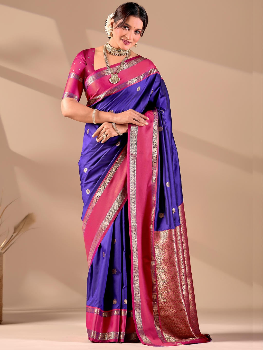Beautiful woman styled in a violet woven design silk saree featuring a heavy zari border and solid blouse by Samantha.