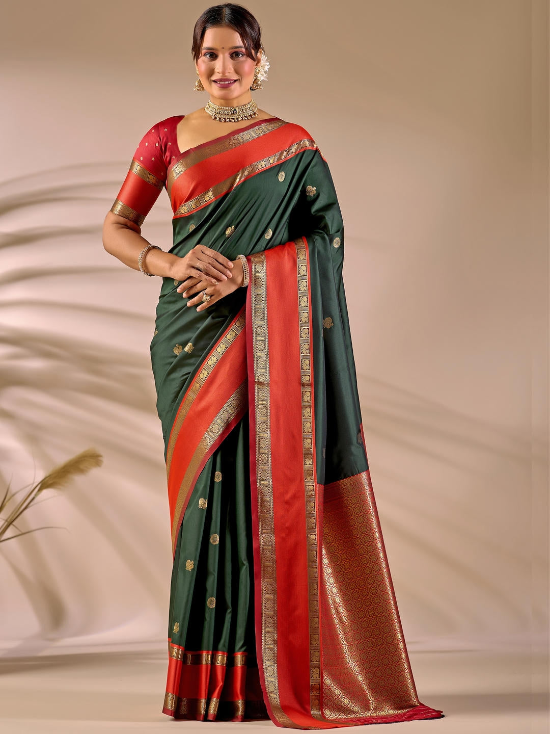 Beautiful woman styled in a metallic green woven design silk saree featuring a heavy zari border and solid blouse by Samantha.