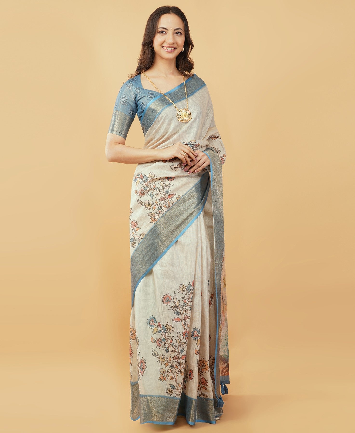 Cream and dusty blue Kalamkari peacock print saree with zari border and tassel pallu