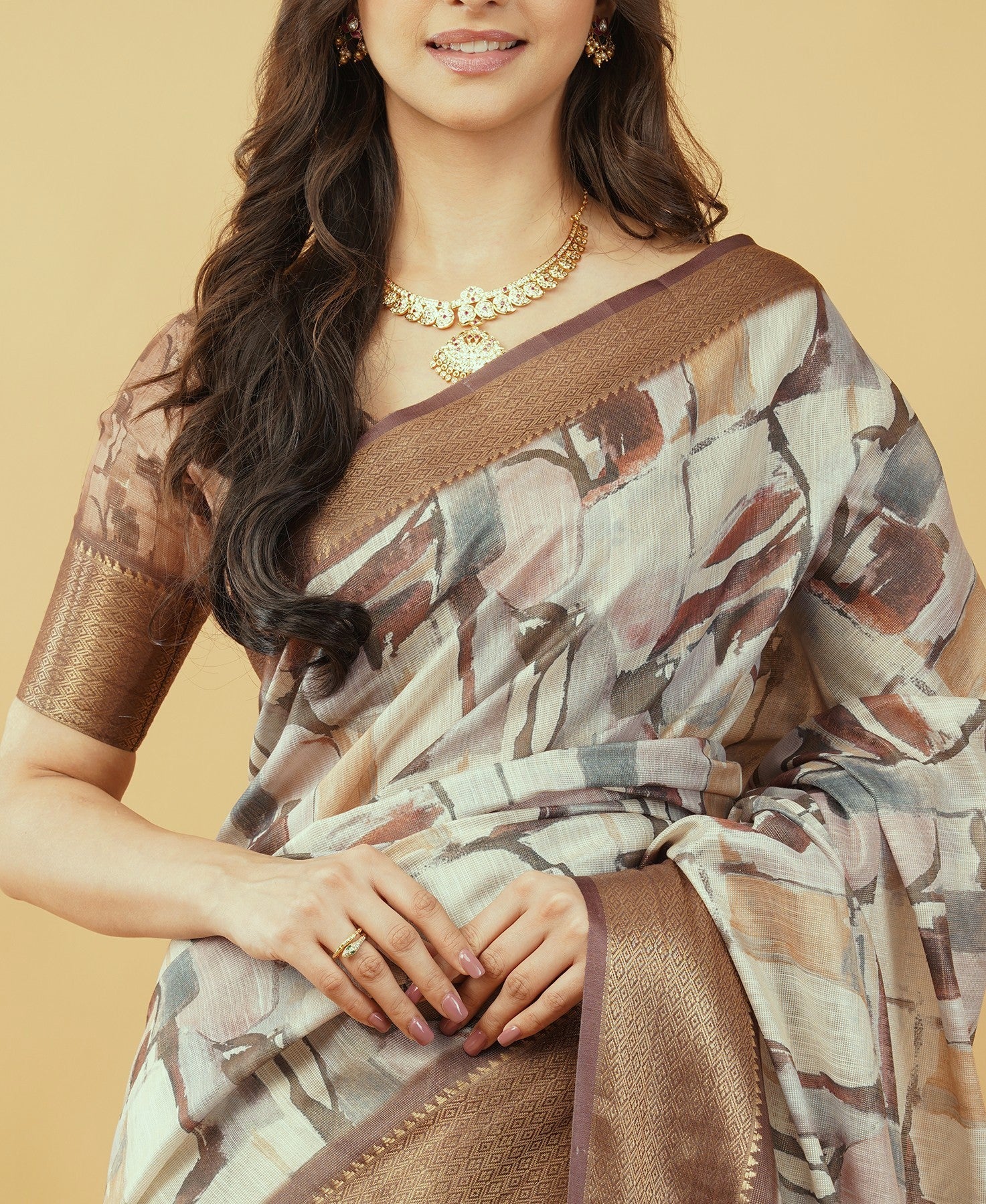 Cream and brown abstract block print saree with bronze zari border and tassel pallu