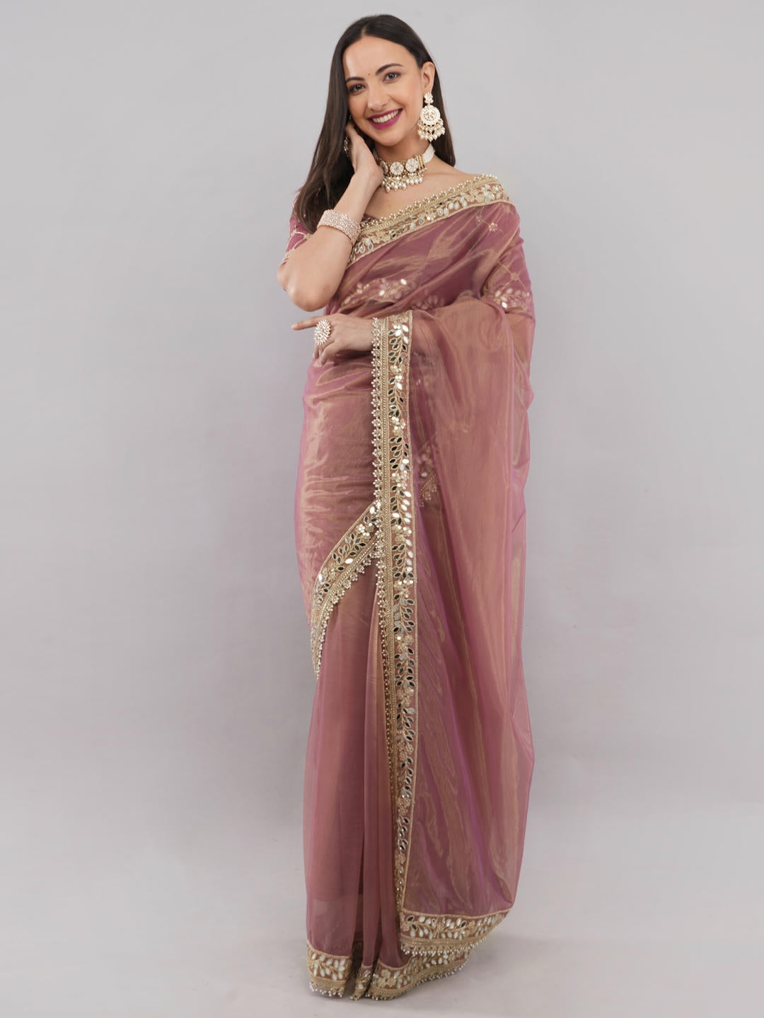 Beautiful woman styled in a classic rust nettwill sheer saree featuring elegant tonal embroidery and a matching unstitched blouse by Samantha.