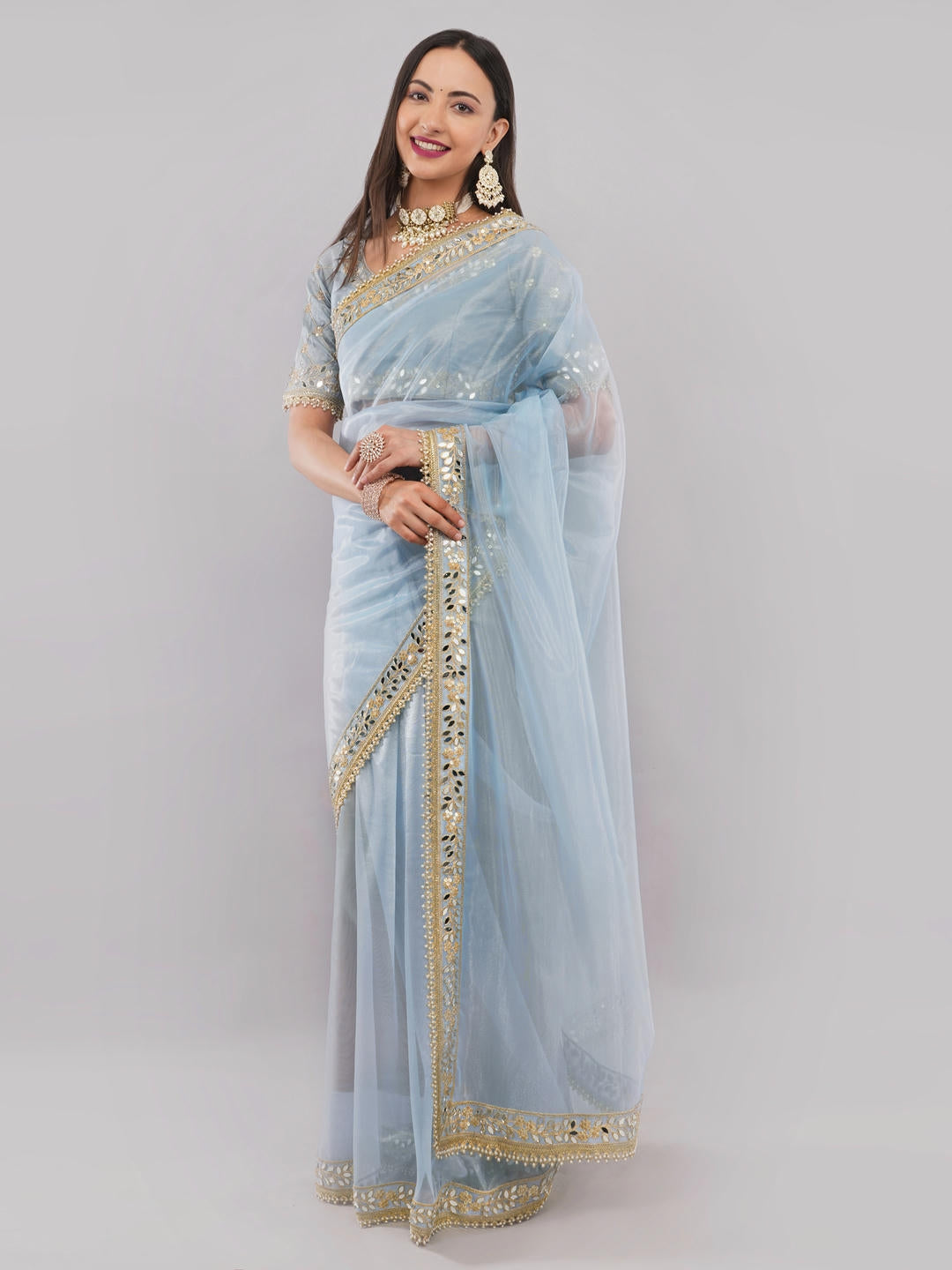 Beautiful woman styled in a classic sky blue nettwill sheer saree featuring elegant tonal embroidery and a matching unstitched blouse by Samantha.
