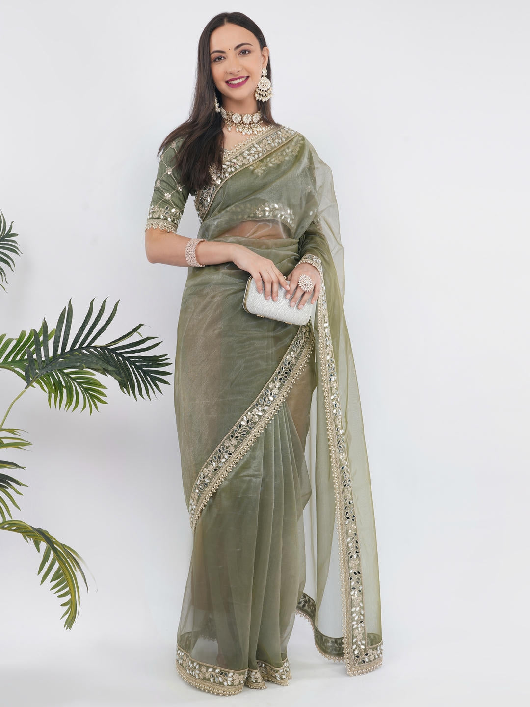 Beautiful woman styled in a classic mehendi green nettwill sheer saree featuring elegant tonal embroidery and a matching unstitched blouse by Samantha.