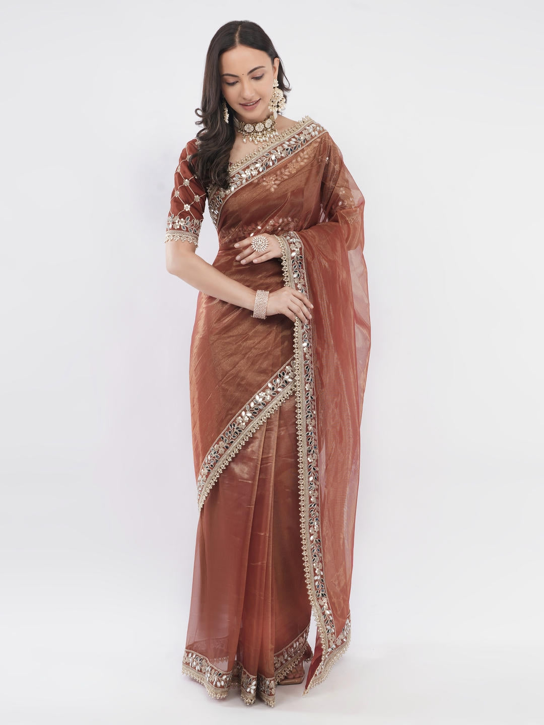 Beautiful woman styled in a classic rusty brown nettwill sheer saree featuring elegant tonal embroidery and a matching unstitched blouse by Samantha.