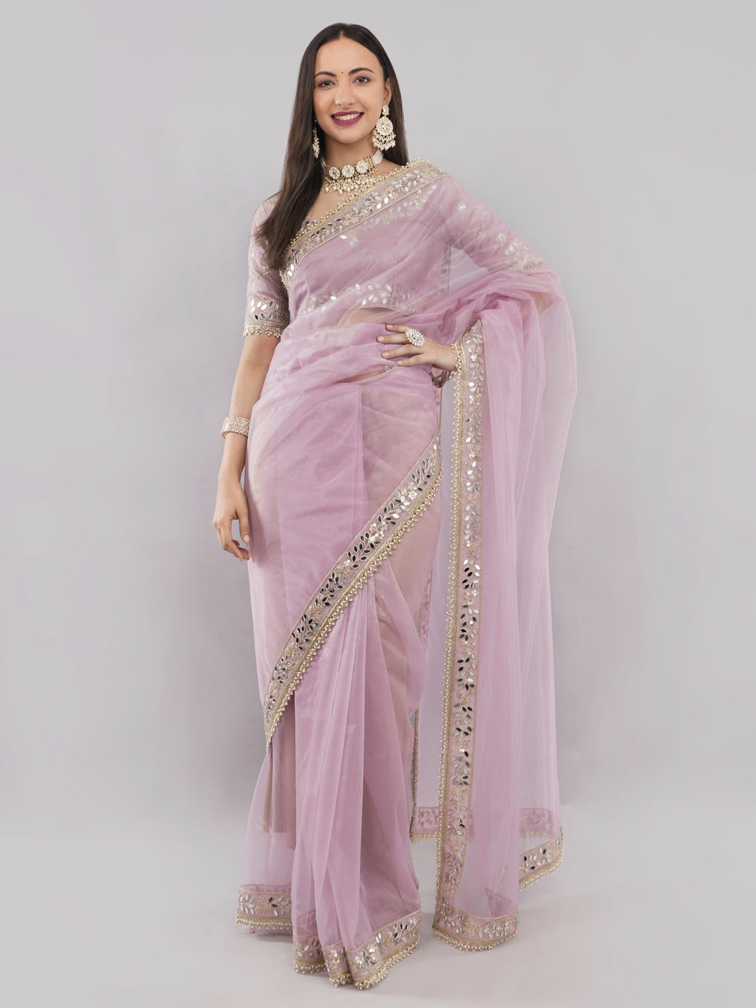 Beautiful woman styled in a classic baby pink nettwill sheer saree featuring elegant tonal embroidery and a matching unstitched blouse by Samantha.