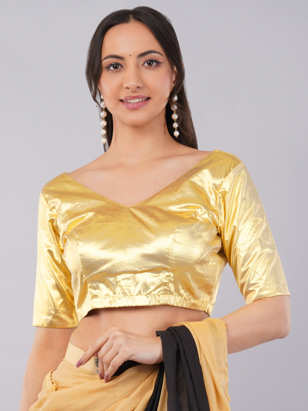 Woman wearing gold brocade v-neck blouse with elbow sleeves