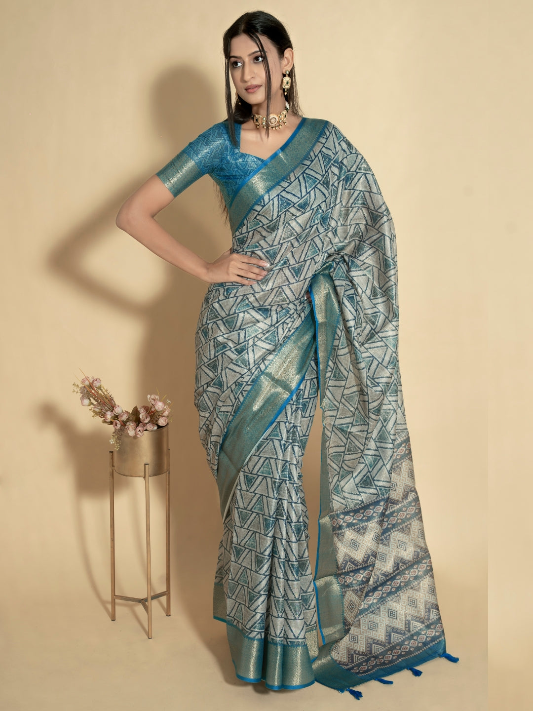 Silver grey geometric triangle print saree with muted gold zari border and teal blue ruched blouse