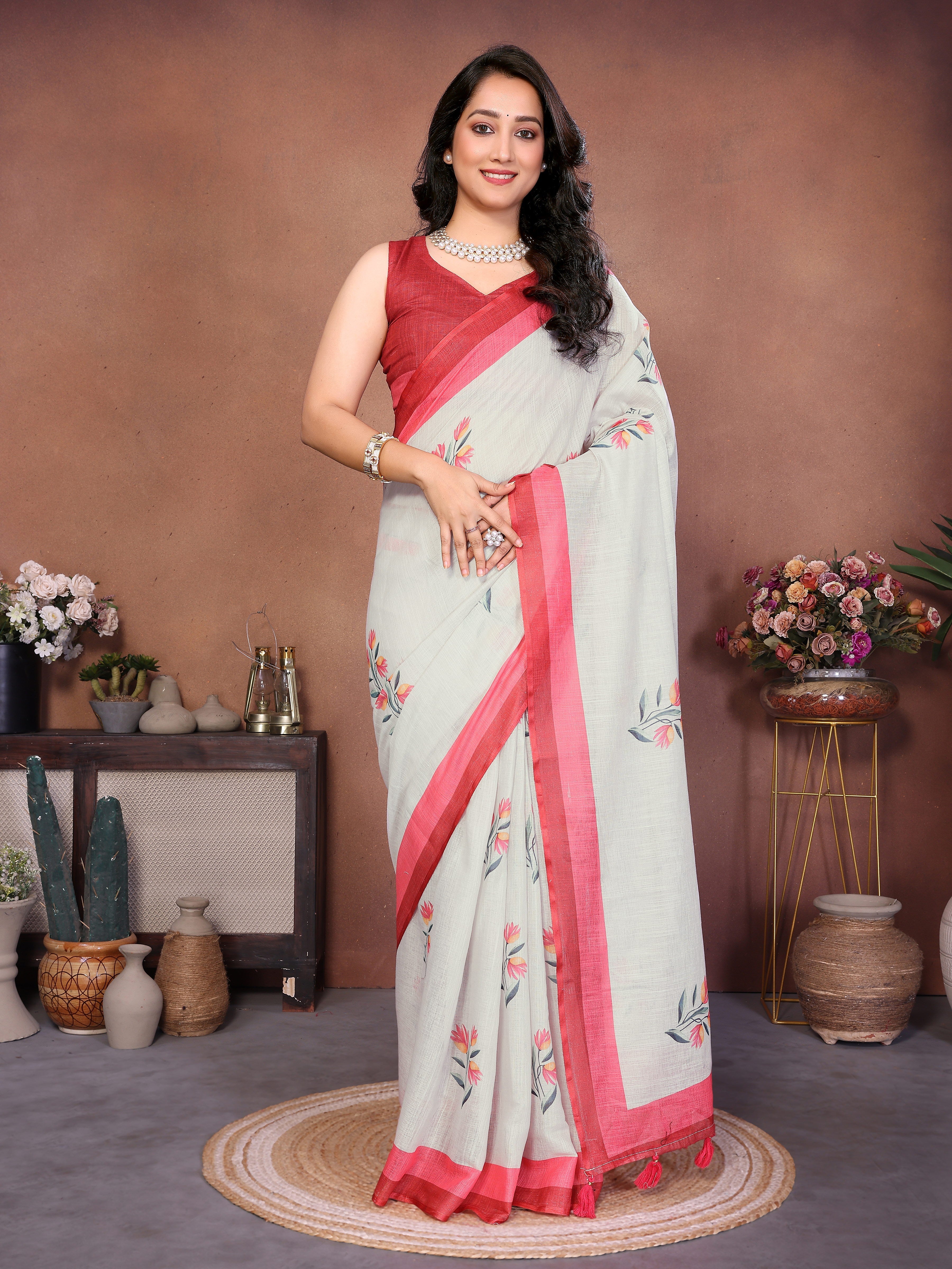 Off-white linen ready-to-wear saree with red border, floral motifs, pocket and tassel detailing