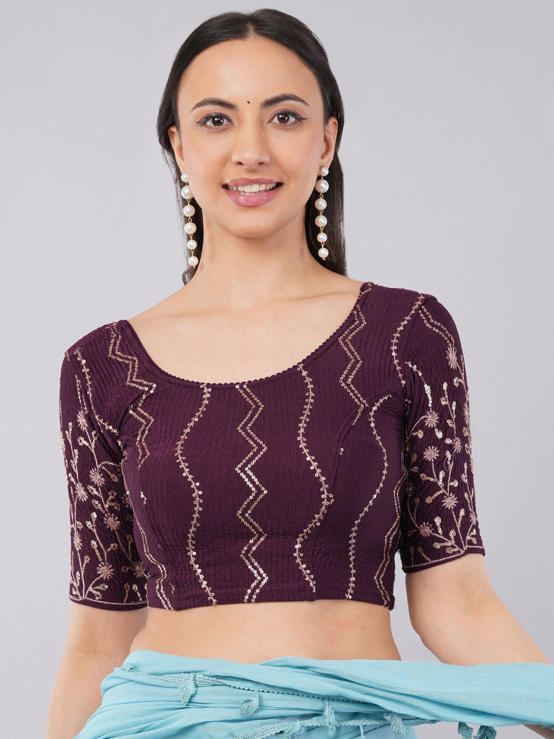 Woman wearing dark purple lycra blouse with zigzag sequin pattern and floral sleeves
