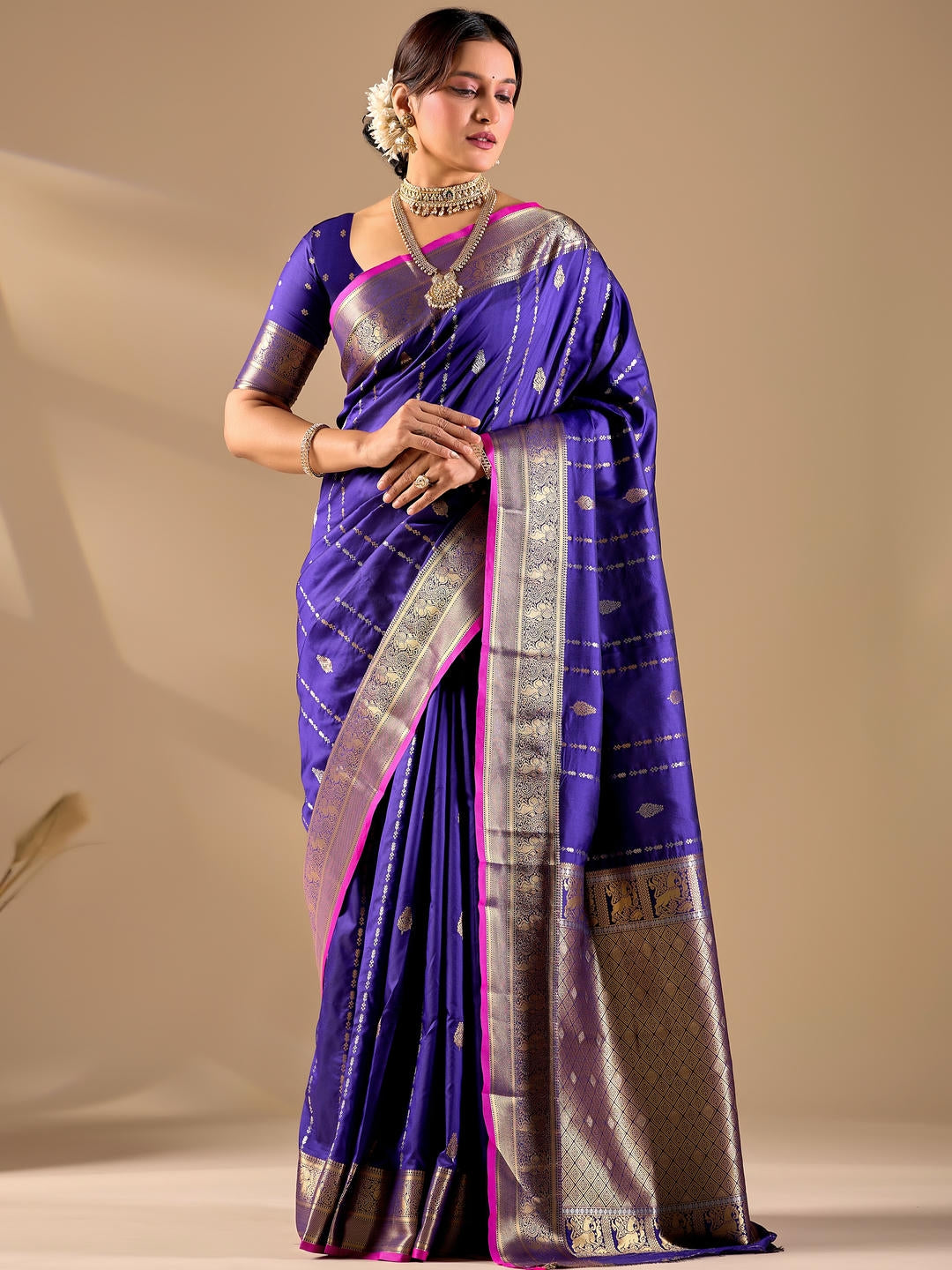 Beautiful woman styled in a blue woven design silk saree featuring a heavy zari border and solid blouse by Samantha.