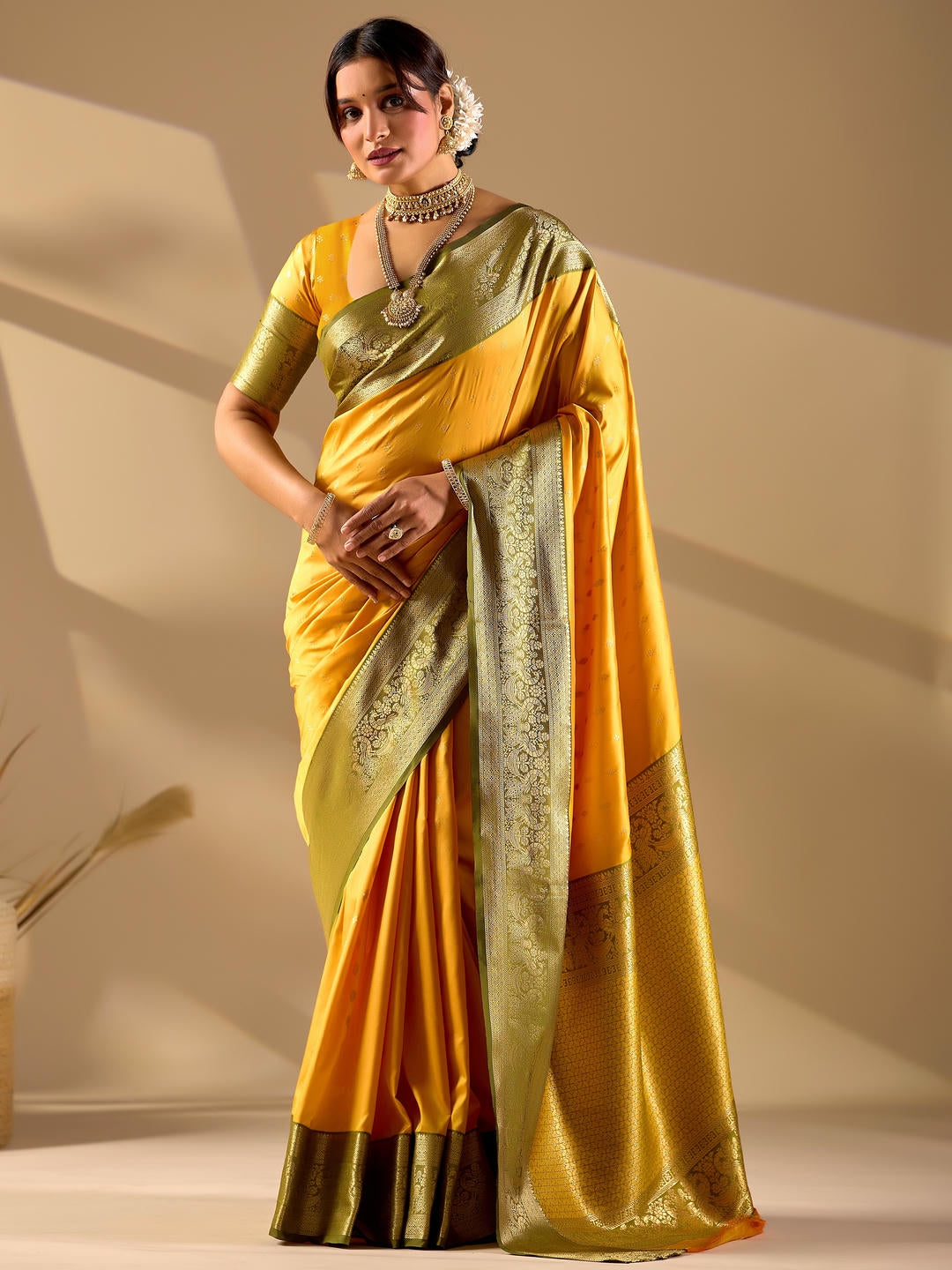 Beautiful woman styled in a yellow woven design silk saree featuring a heavy zari border and solid blouse by Samantha.
