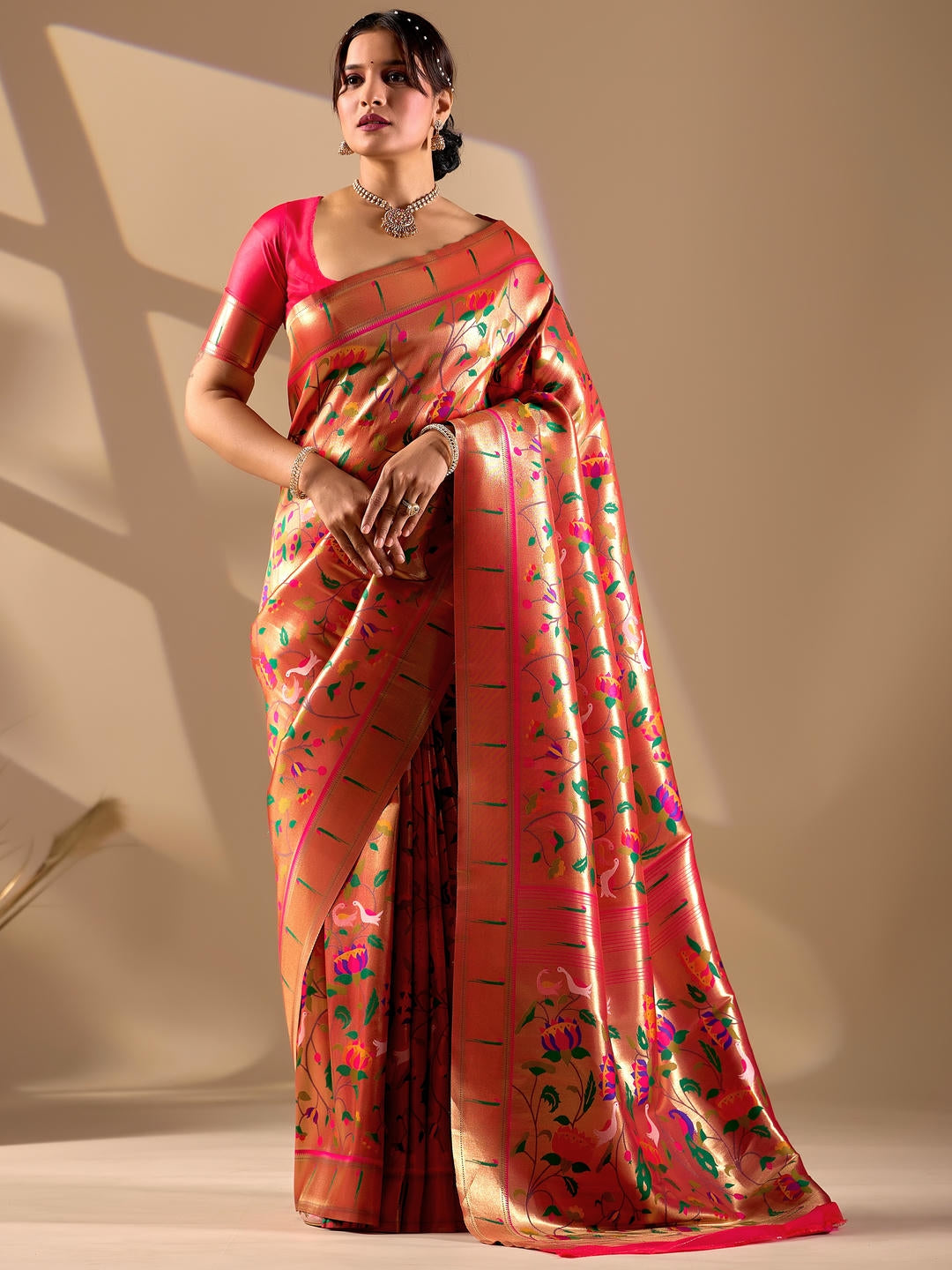 Beautiful woman styled in a gold woven design silk saree featuring a heavy zari border and solid blouse by Samantha.