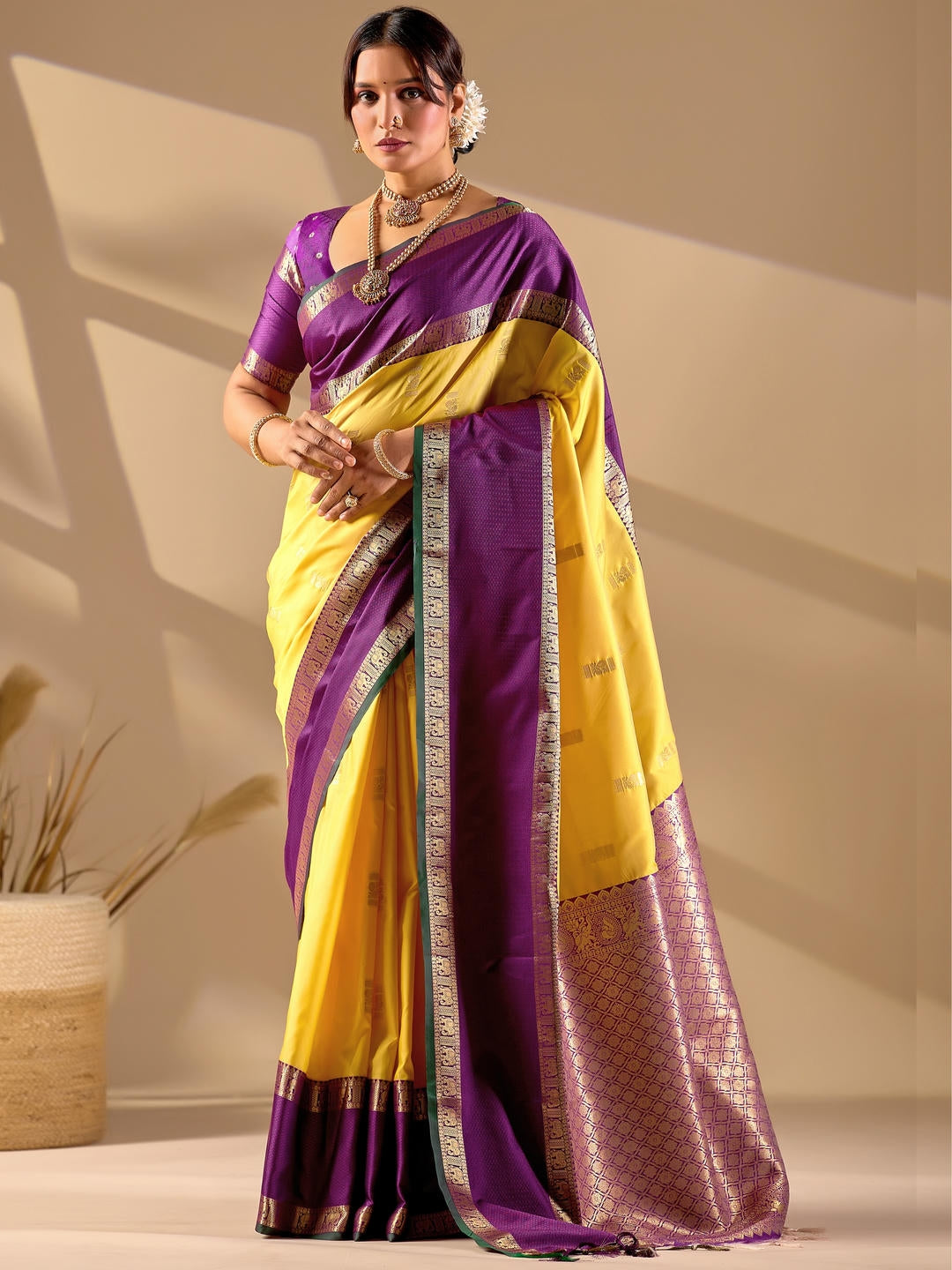 Beautiful woman styled in a yellow woven design silk saree featuring a heavy zari border and solid blouse by Samantha.