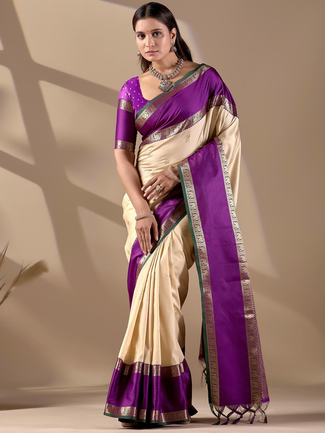Beautiful woman styled in a cream woven design silk saree featuring a heavy zari border and solid blouse by Samantha.