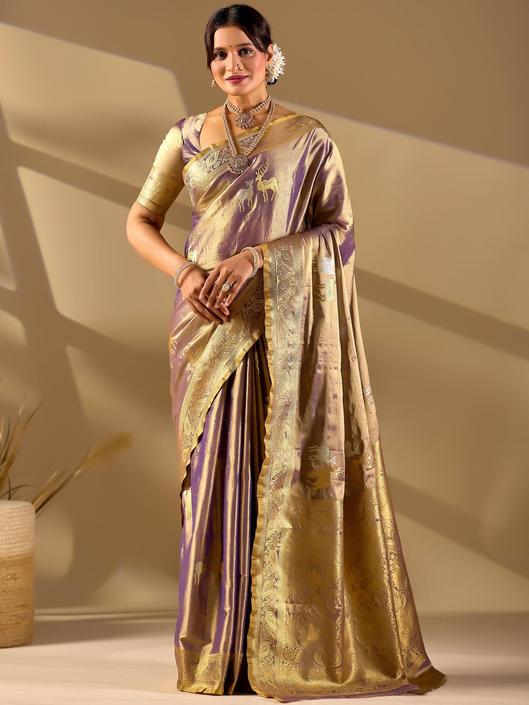 Beautiful woman styled in a deer gold woven design silk saree featuring a heavy zari border and solid blouse by Samantha.