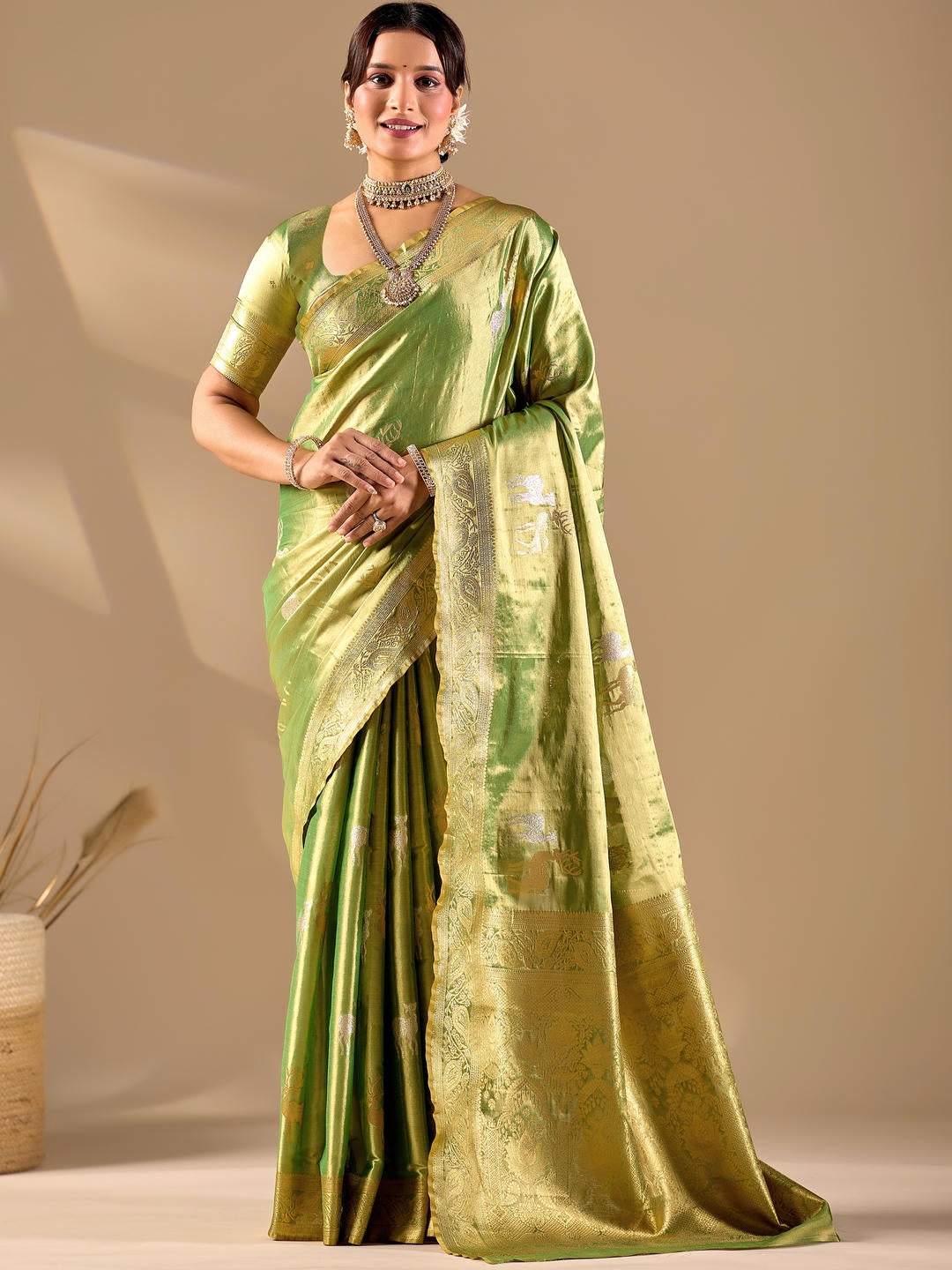 Beautiful woman styled in a green woven design silk saree featuring a heavy zari border and solid blouse by Samantha.