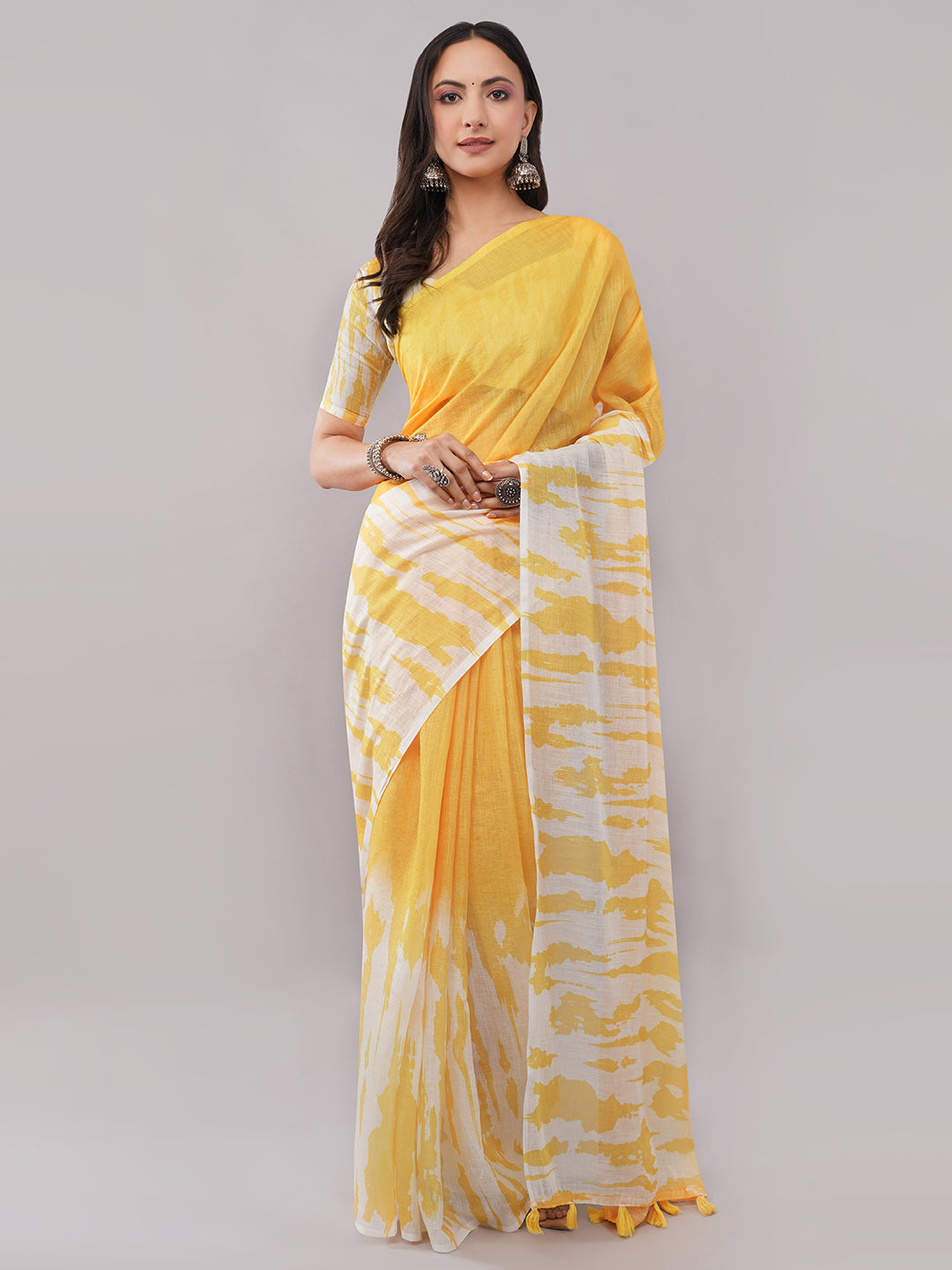 Yellow and white abstract shibori printed linen saree draped by woman for haldi function by Samantha