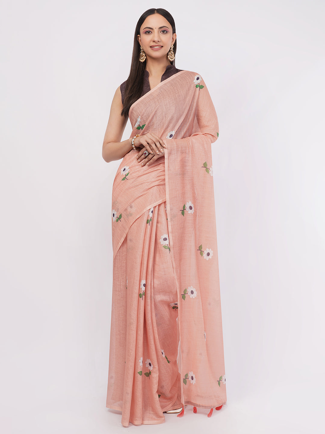Peach linen saree with white floral motifs draped by woman for minimalist office wear by Samantha