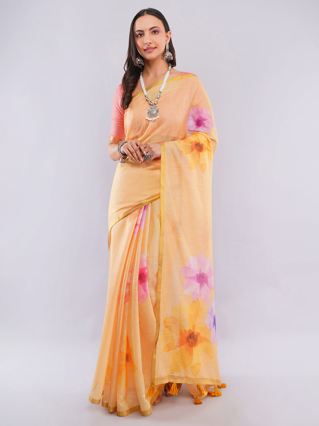 Amber yellow linen saree with watercolor hibiscus floral prints draped by woman for summer festive wear by Samantha