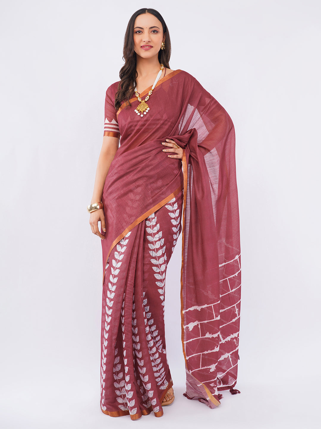 Deep maroon linen saree with white brick and leaf batik print draped by woman for artistic office wear by Samantha