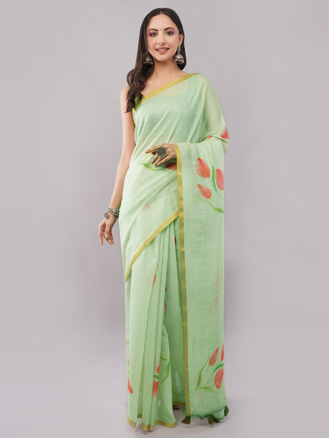 Mint green linen saree with red tulip floral print and gold zari border draped by woman for summer wear by Samantha
