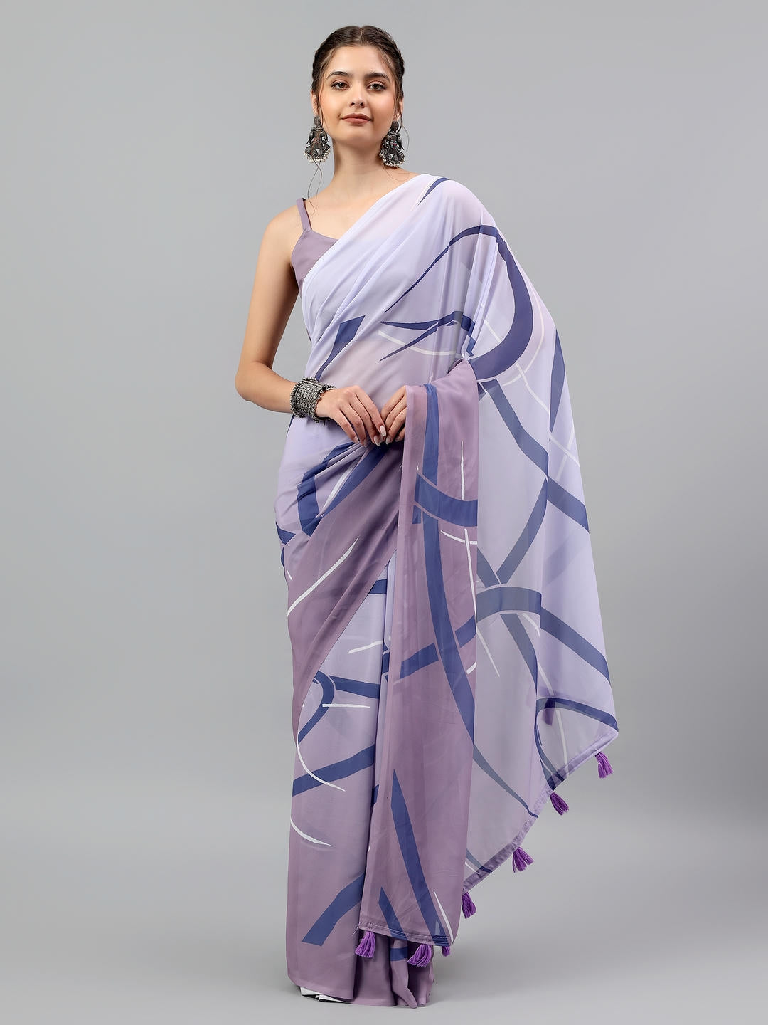 Beautiful woman styled in an ocean blue and white faux georgette saree with modern abstract prints by Samantha.