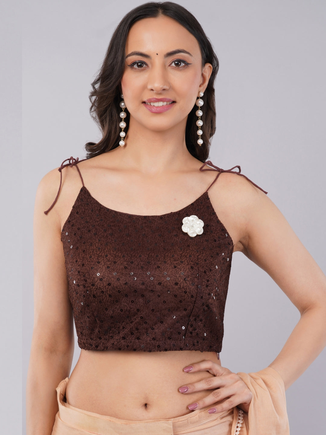 Woman wearing coffee brown sequin blouse with spaghetti tie-up straps
