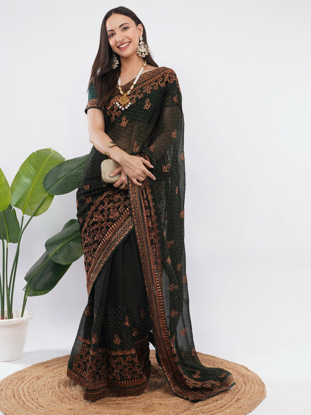 Beautiful woman styled in a classic dark green tissue silk shimmer saree featuring a contrast red zari border and a matching unstitched red blouse by Samantha.