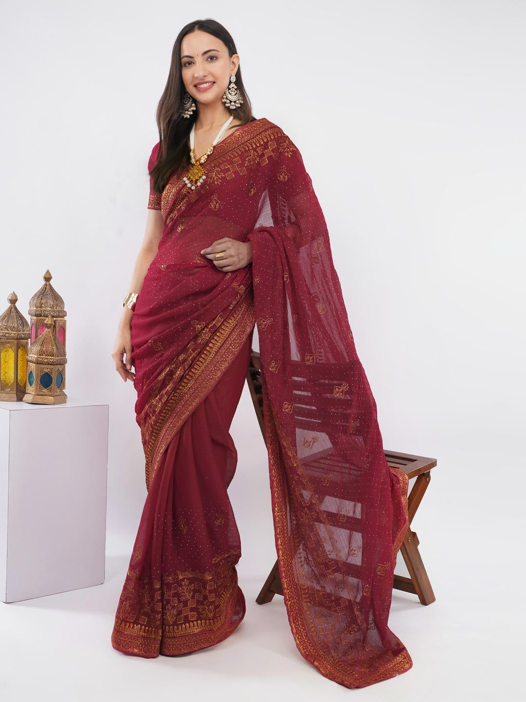 Beautiful woman styled in a classic metallic red tissue silk shimmer saree featuring a contrast dark green zari border and a matching unstitched green blouse by Samantha.