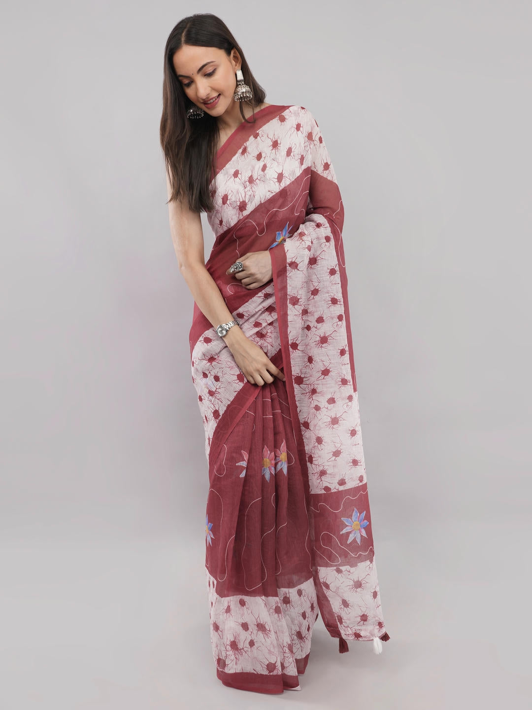 Beautiful woman styled in a classic maroon and white floral printed linen saree featuring a refreshing botanical design, geometric border, and a matching unstitched blouse by Samantha.