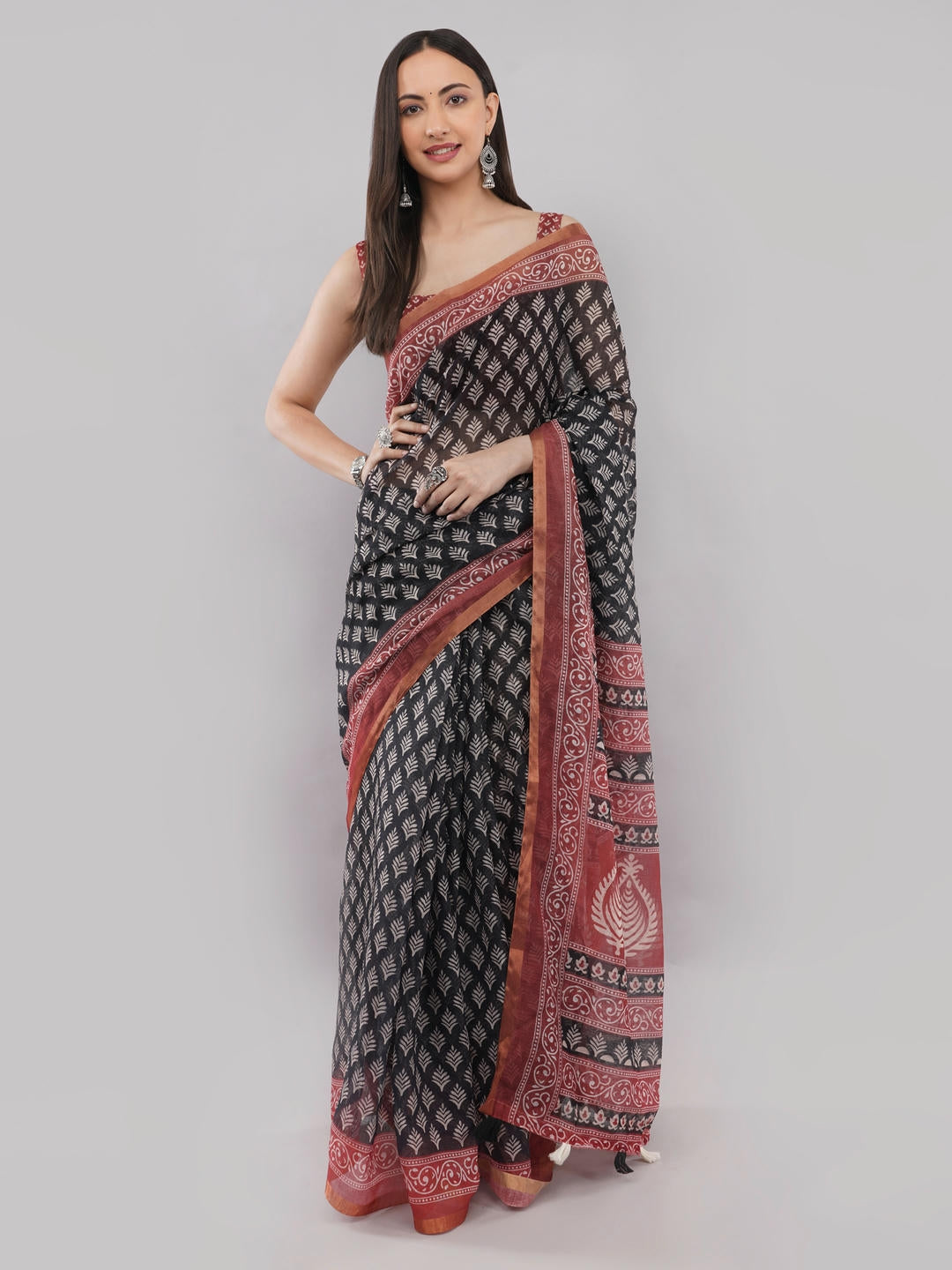 Beautiful woman styled in a classic off white linen saree featuring bold black and red floral prints, a geometric border, and a matching unstitched blouse by Samantha.