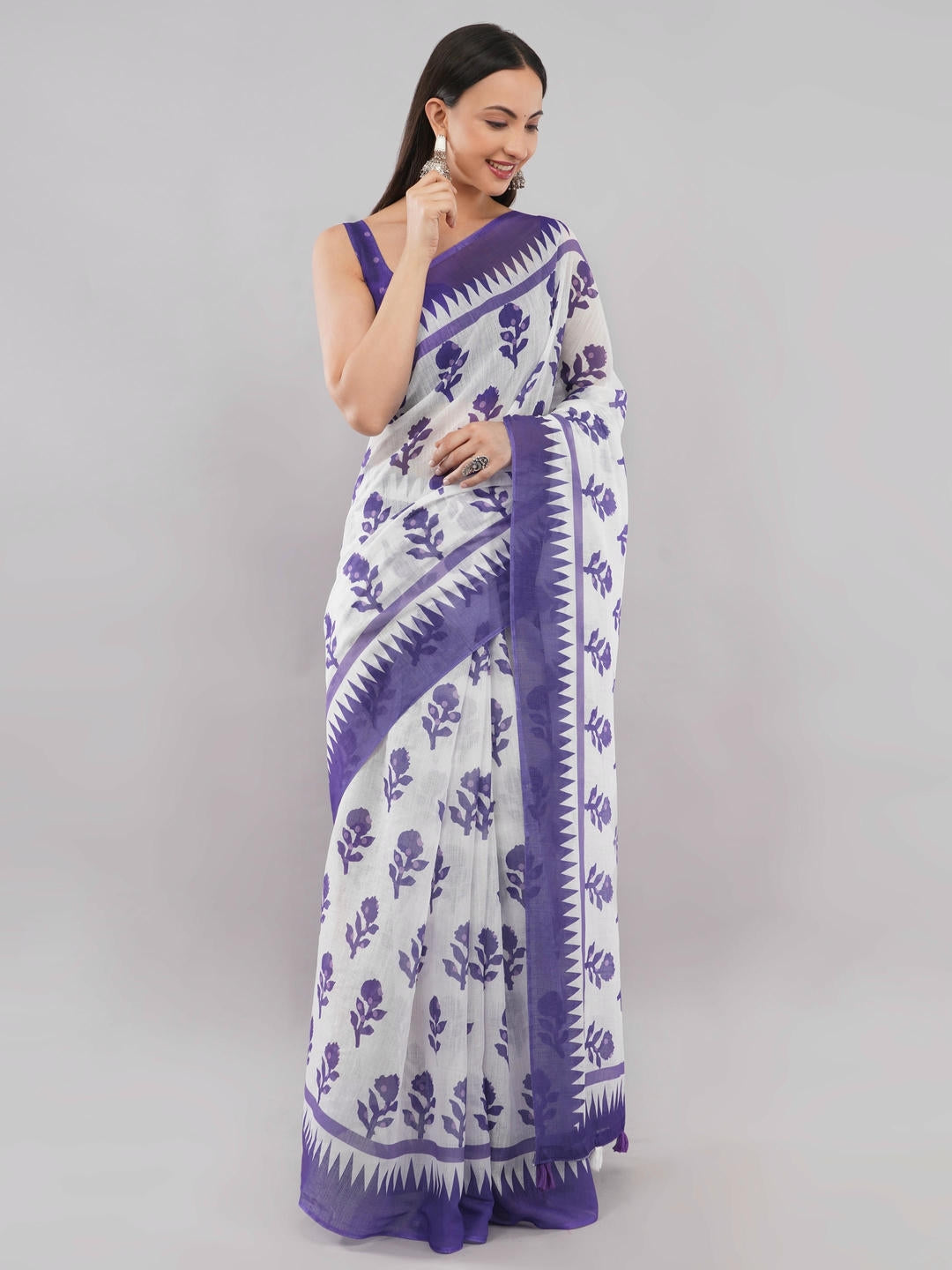 Beautiful woman styled in a classic off white linen saree featuring bold violet floral prints, a geometric border, and a matching unstitched blouse by Samantha.